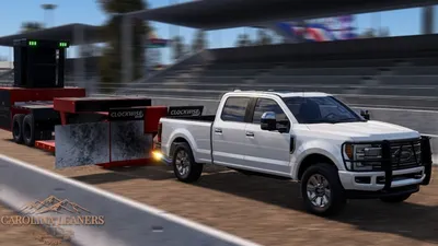 A white truck towing a sled at the pull track with motion blur