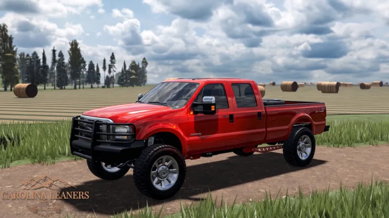 A sensible first truck — a leveled red Super Duty with a brush guard at the farm showcase
